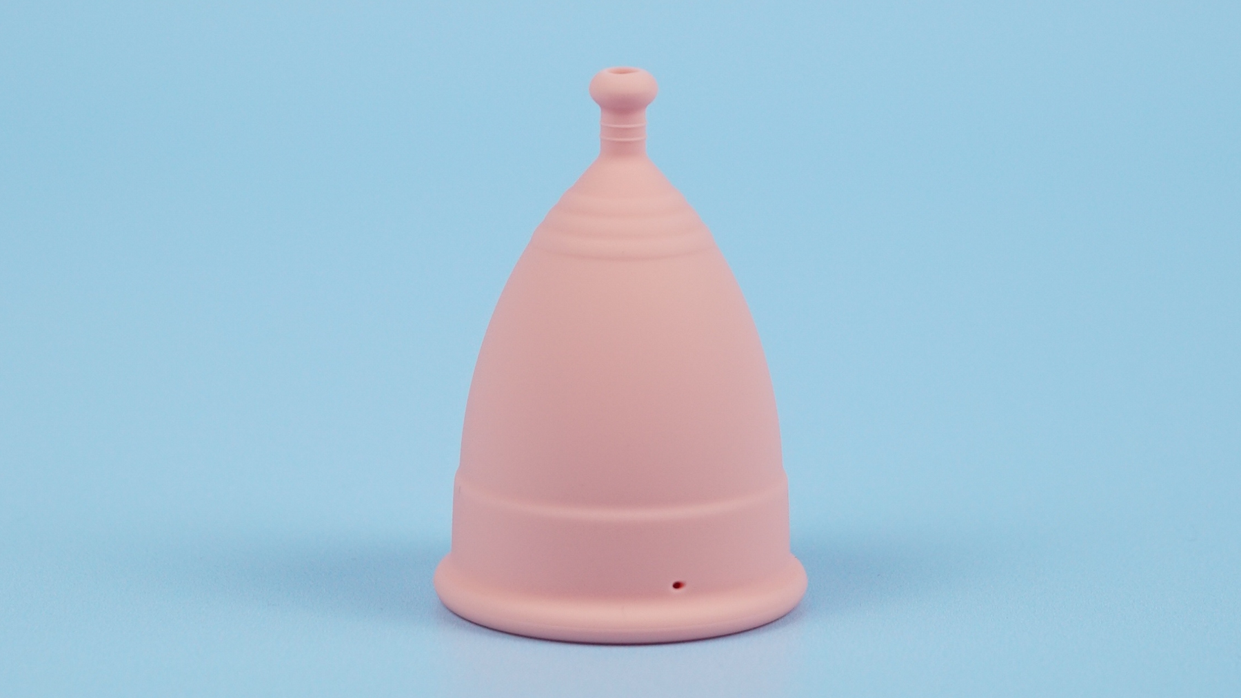 nudie period cup standing on blue backdrop
